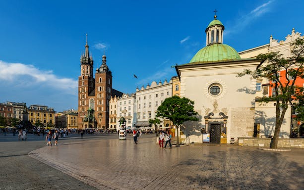 Krakow Old Town square with St. Mary's Basilica and historic buildings.