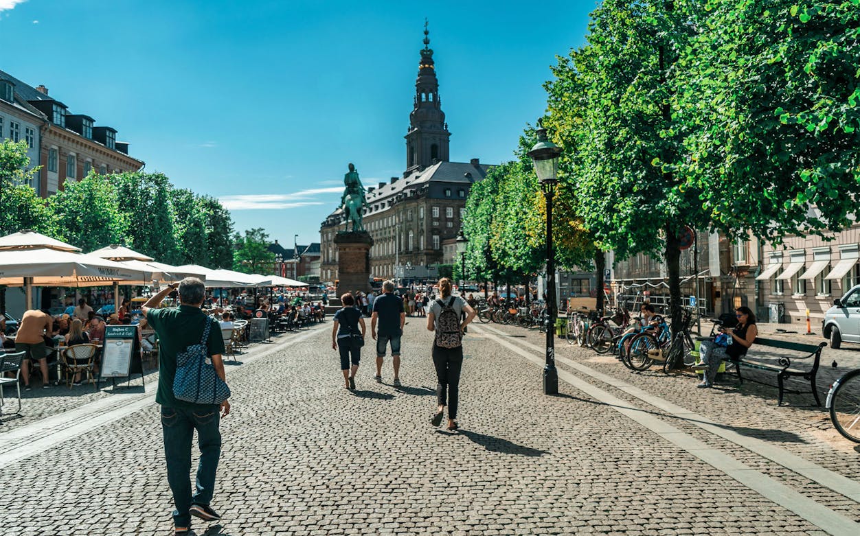 Walking tour in Copenhagen with view of Christiansborg Palace in the background.