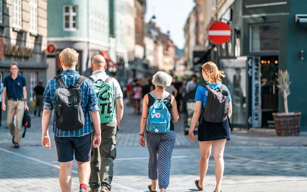 Tourists walking on a bustling street in Copenhagen during a city walking tour.