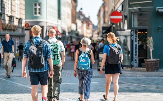 Tourists walking on a bustling street in Copenhagen during a city walking tour.