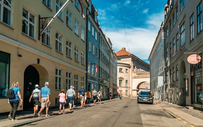 Group walking through Copenhagen Old Town street with historic buildings.