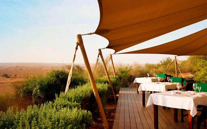 Outdoor dining area at Al Maha Desert Resort & Spa Dubai with desert view.