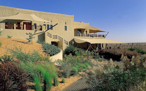 Al Maha Desert Resort & Spa Dubai with desert landscape and traditional architecture.