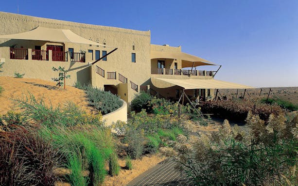 Al Maha Desert Resort & Spa Dubai with desert landscape and traditional architecture.