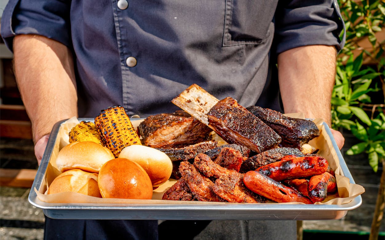 Barbecue platter with grilled meats, corn, and buns at JW Marriott Marquis Dubai.
