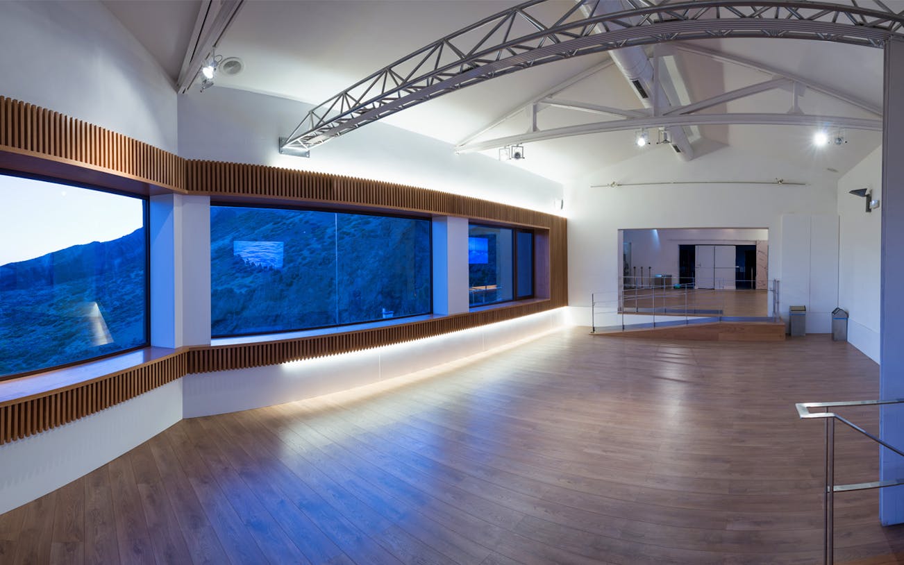 Observatory interior with large windows overlooking Mount Teide landscape.