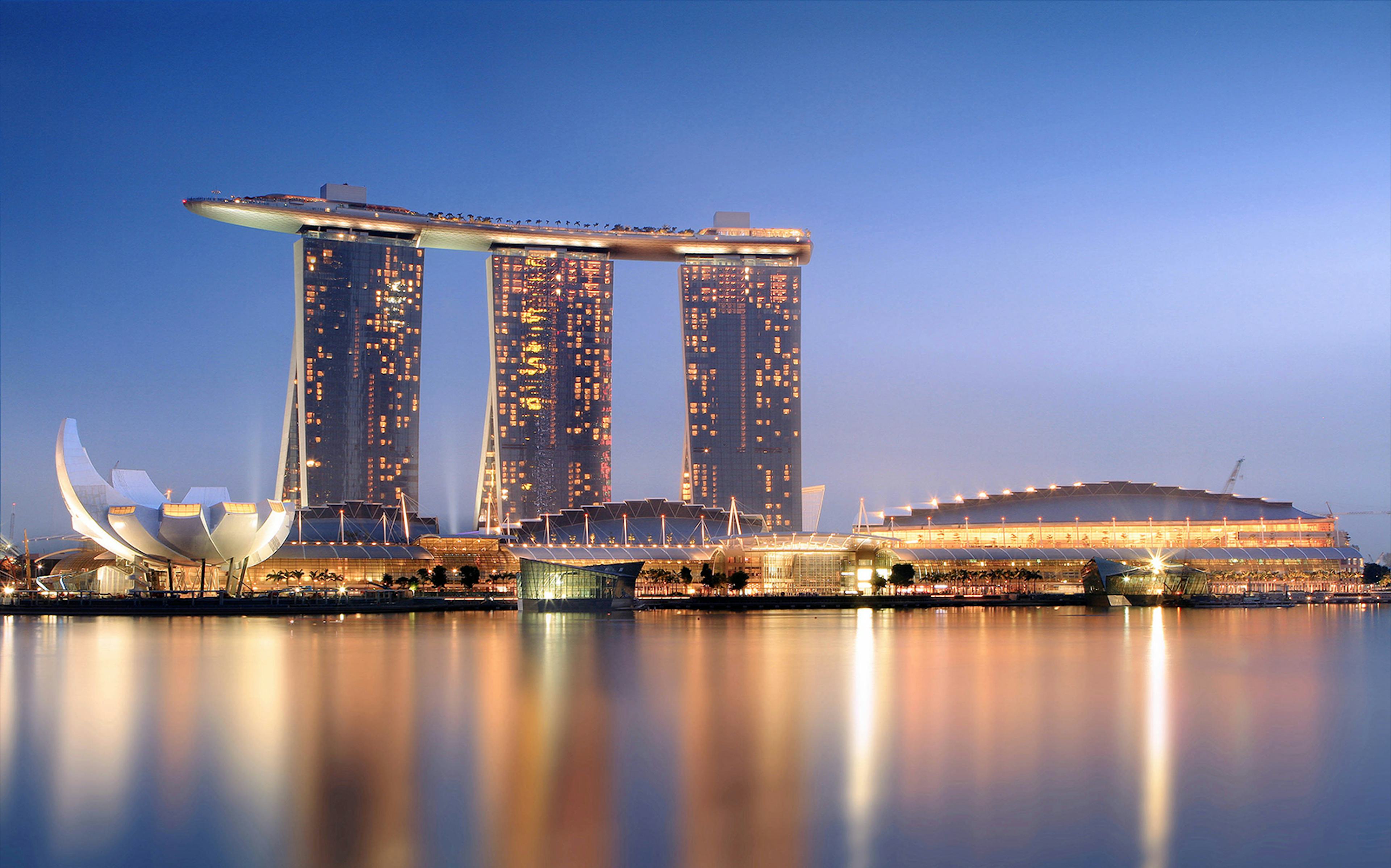 Singapore Flyer view with Marina Bay Sands Skypark illuminated at dusk.