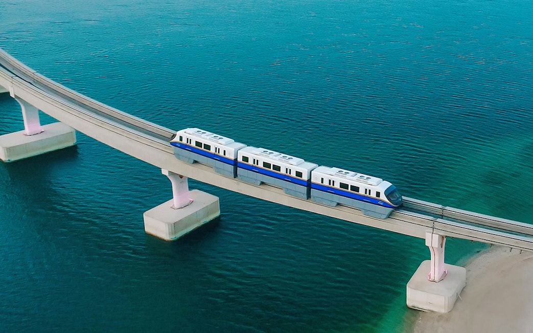 Palm Monorail traveling over water towards Nakheel Mall in Dubai.