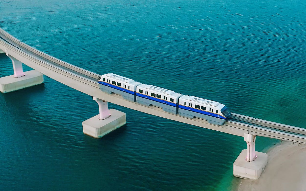 Palm Monorail traveling over water towards Nakheel Mall in Dubai.