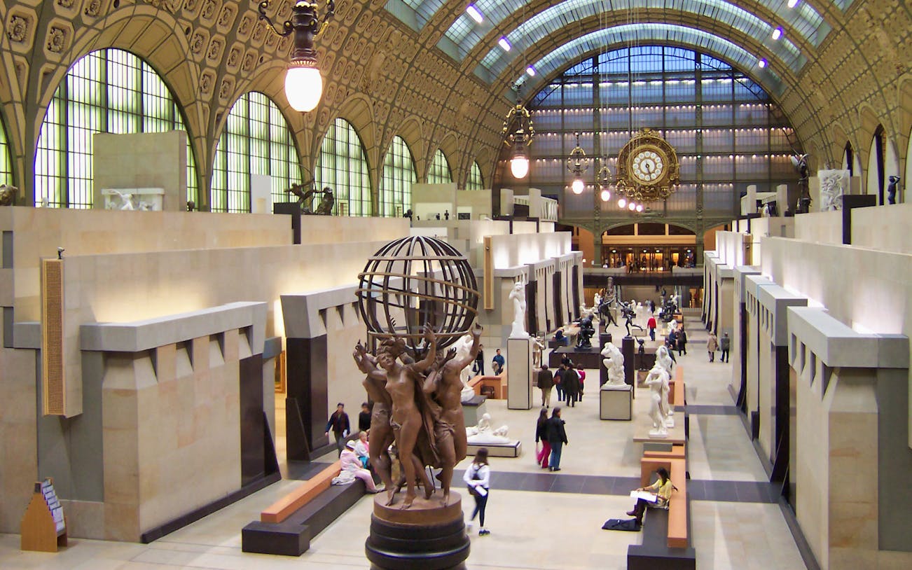 Orsay Museum interior with sculptures and visitors in Paris, France.