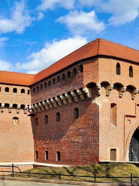 Kraków Barbican, medieval fortress with red brick walls and conical towers, Poland.