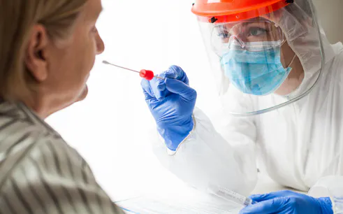 Healthcare worker administering home PCR test.