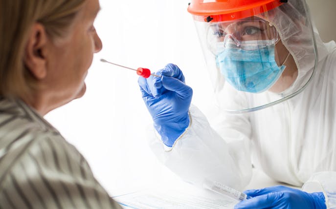 Healthcare worker administering home PCR test.