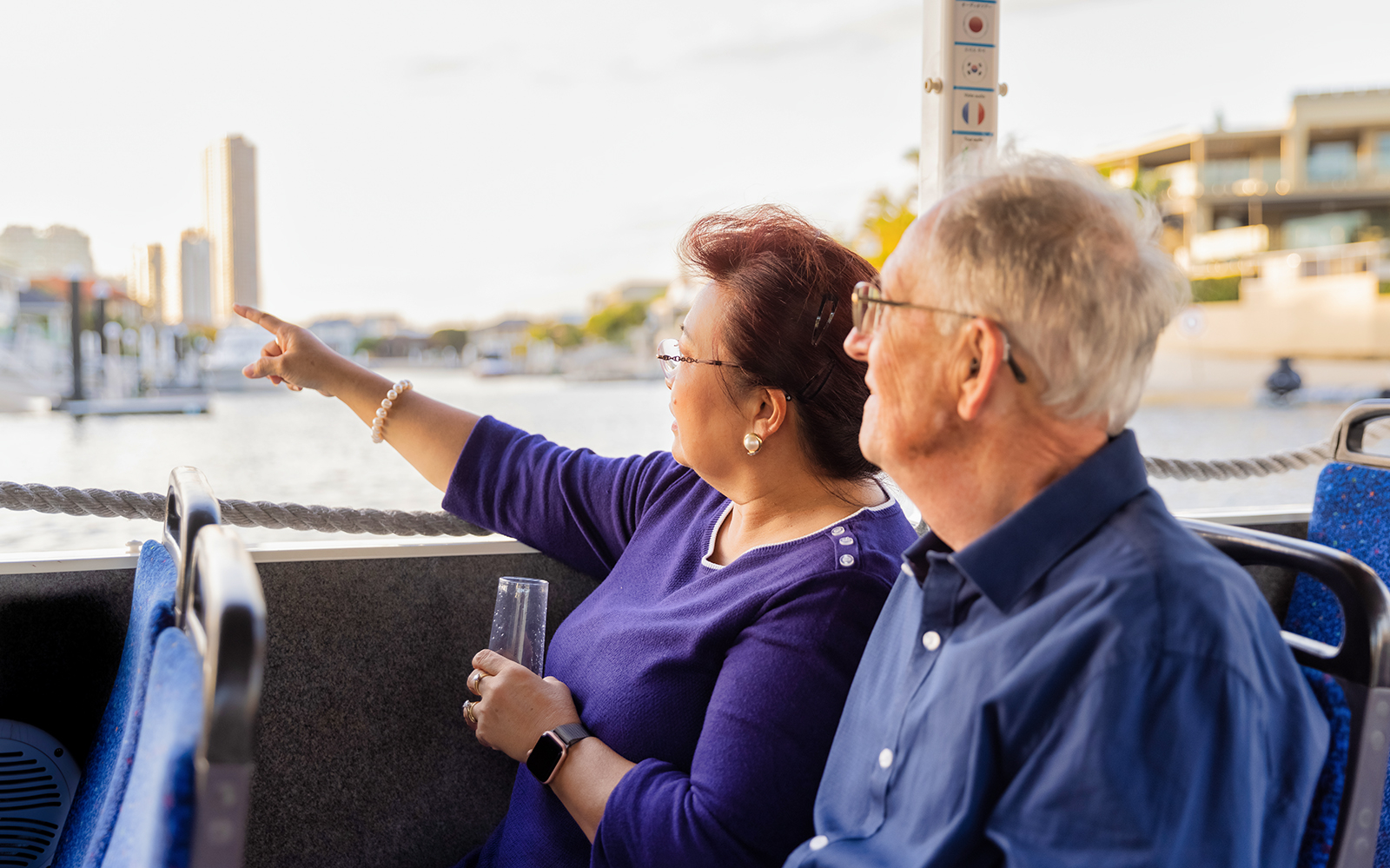 Couple enjoying Aquaduck Gold Coast tour, pointing at city skyline.