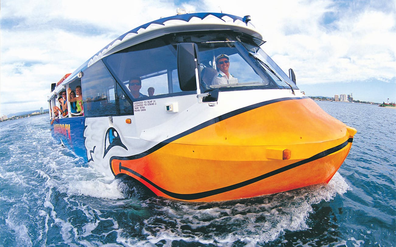 Aquaduck tour vehicle cruising on water with passengers enjoying the view.