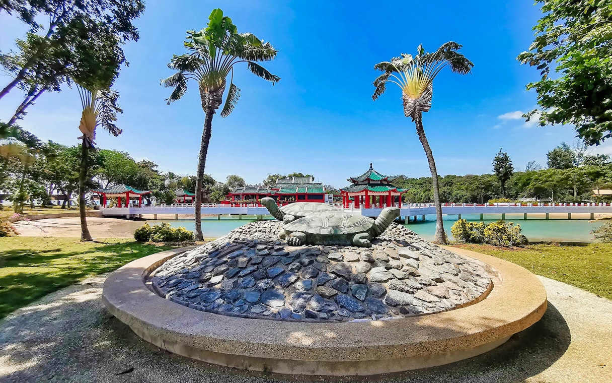 Kusu Island turtle statue with Chinese temple in background, Singapore.
