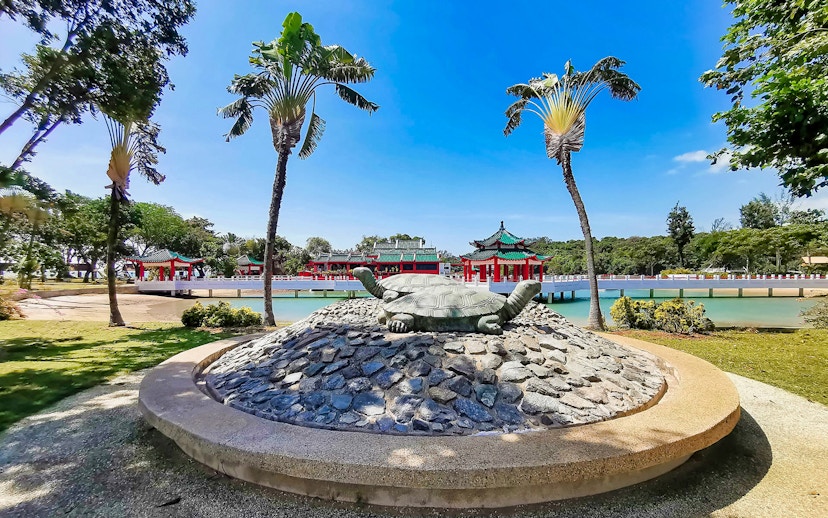 Kusu Island turtle statue with Chinese temple in background, Singapore.