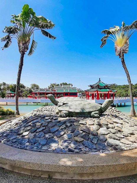 Kusu Island turtle statue with Chinese temple in background, Singapore.