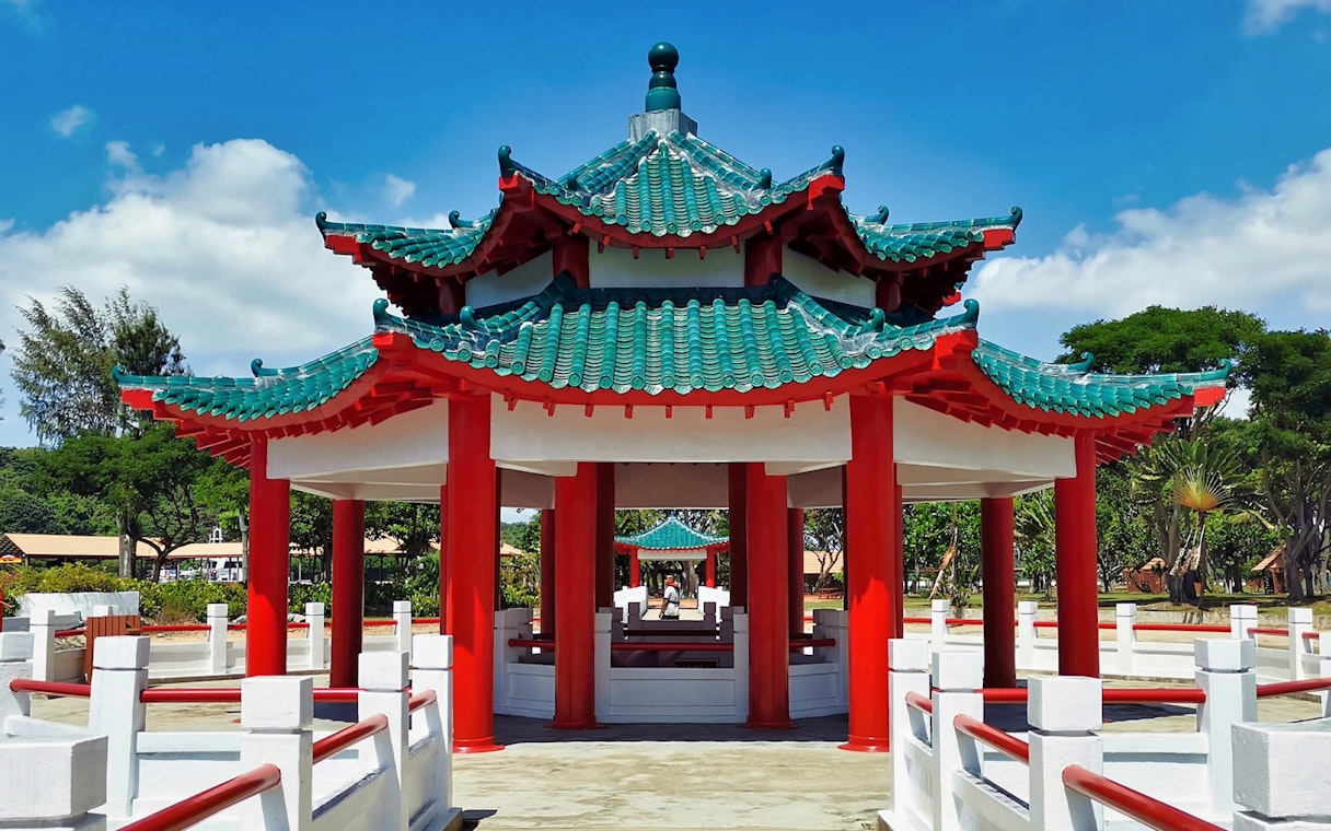 Pagoda on Kusu Island, Singapore, with red pillars and green tiled roof.