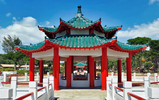 Pagoda on Kusu Island, Singapore, with red pillars and green tiled roof.
