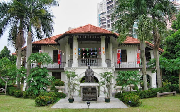 Sun Yat Sen Nanyang Memorial Hall with statue and flags in Singapore.