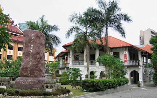 Sun Yat Sen Nanyang Memorial Hall with statue and palm trees in Singapore.