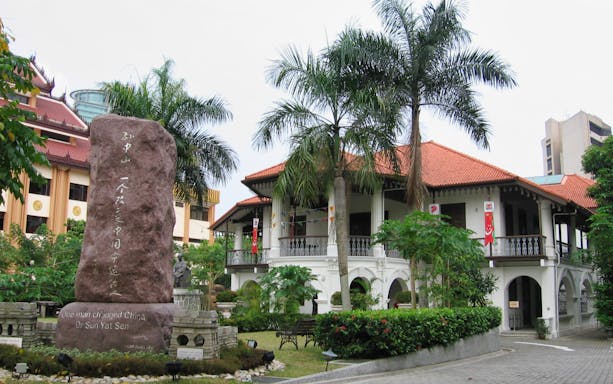 Sun Yat Sen Nanyang Memorial Hall with statue and palm trees in Singapore.
