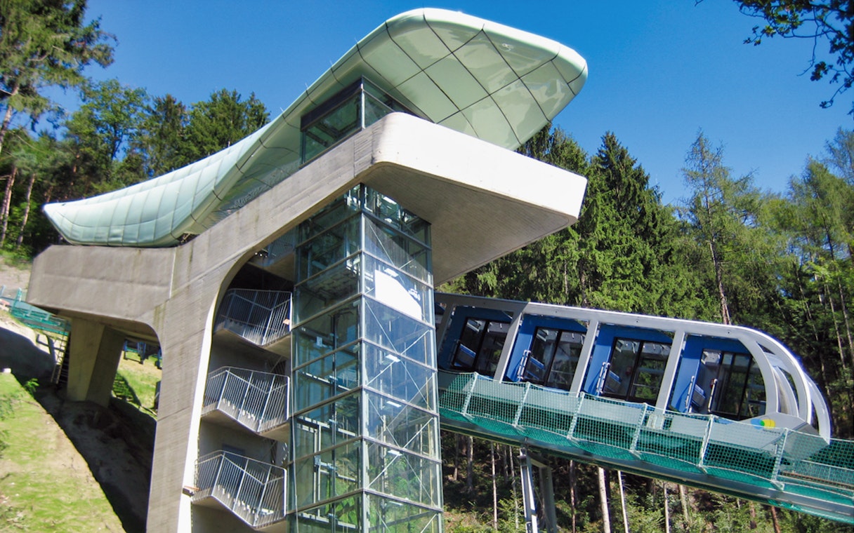 Funicular ascending to Hungerburgbahn station surrounded by forest.