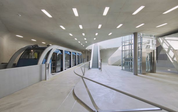 Hungerburgbahn funicular station interior with escalator and train in Innsbruck.