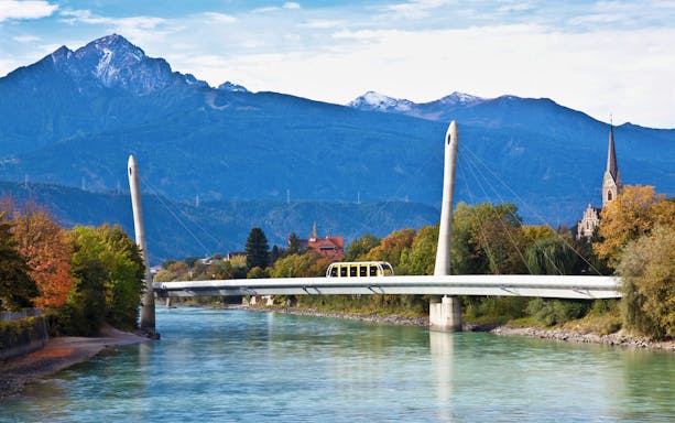 Hungerburgbahn funicular crossing bridge with mountains in Innsbruck, Austria.
