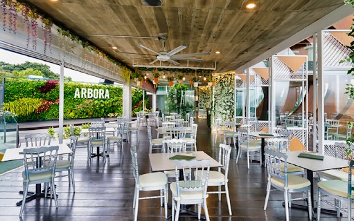 Outdoor dining area at Arbora, Mount Faber, with greenery and seating.