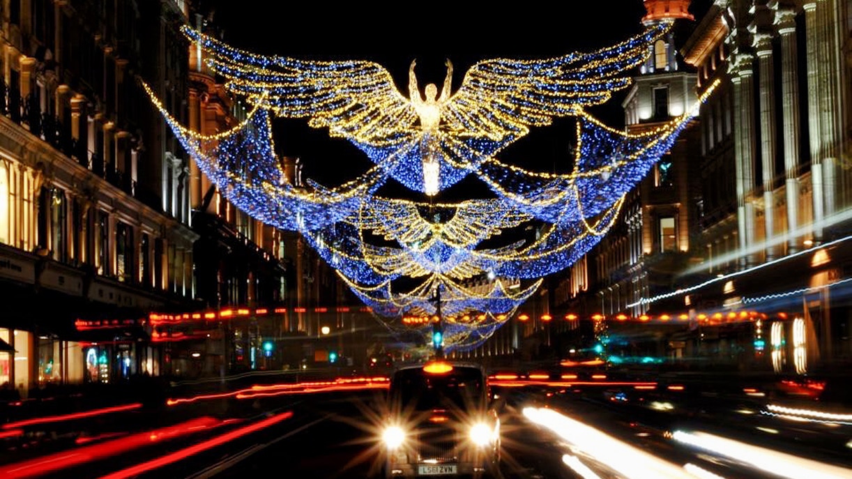 Christmas lights shaped like angels over a busy London street on Christmas Eve.