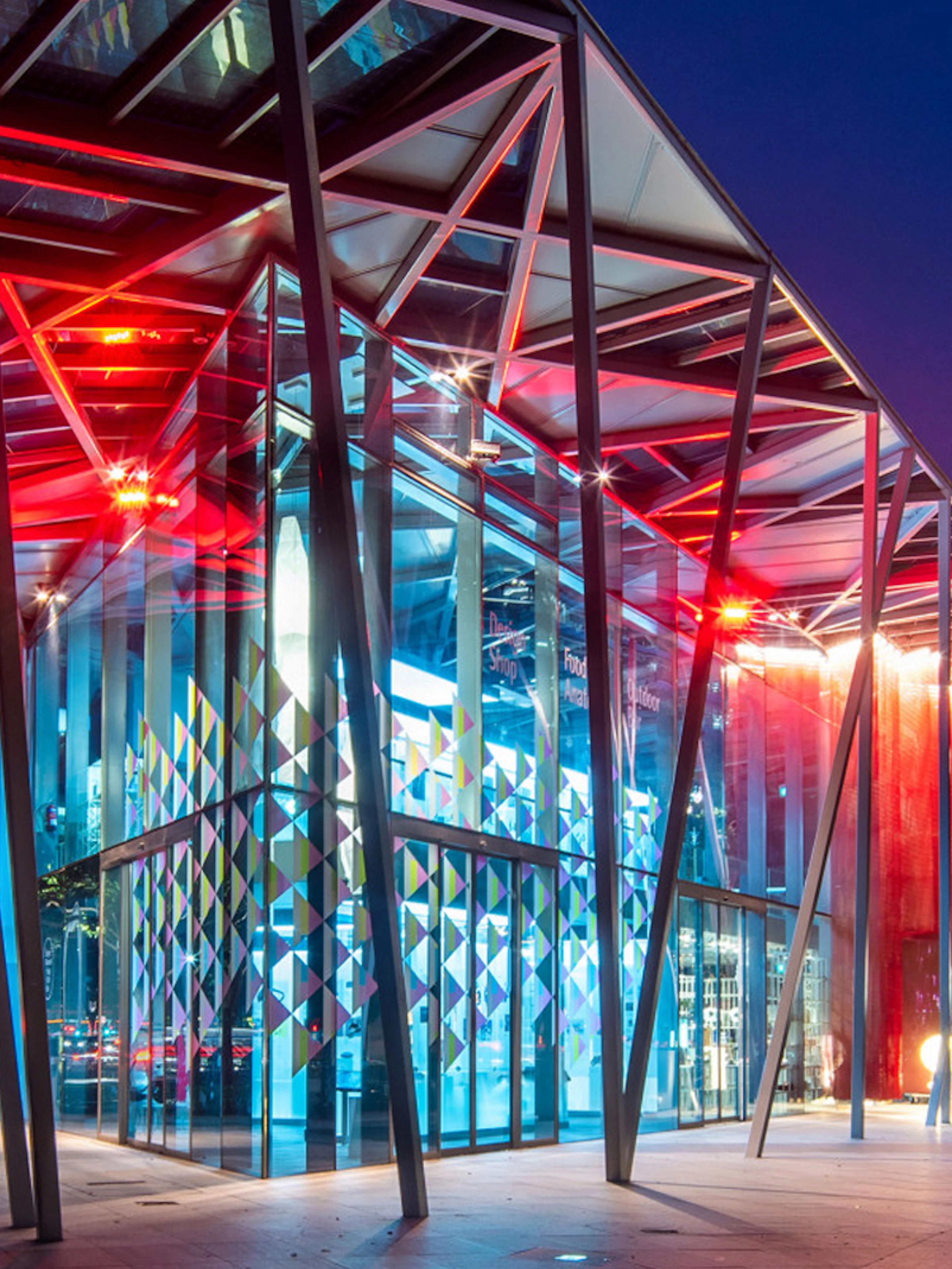 Red Dot Design Museum entrance illuminated at night, Singapore.