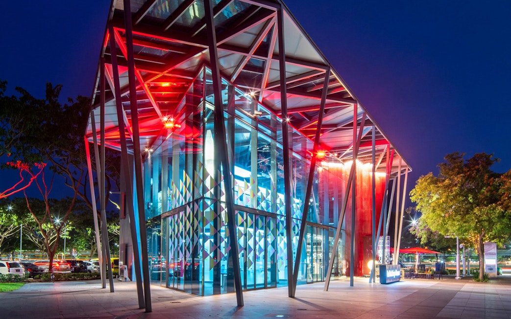 Red Dot Design Museum entrance illuminated at night, Singapore.