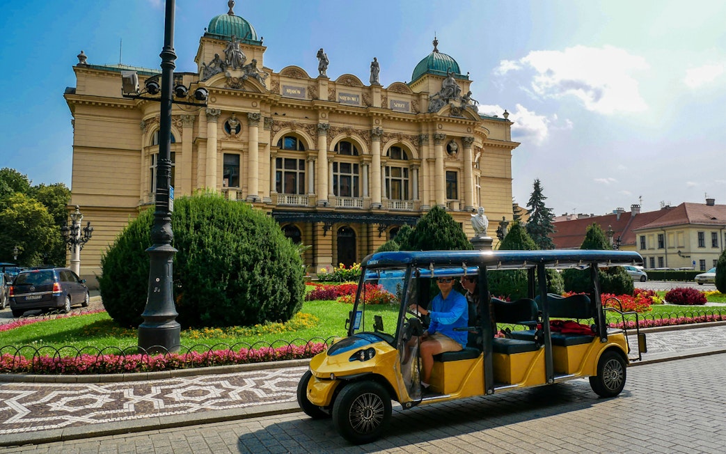 Electric car tour passing by the Juliusz Słowacki Theatre in Krakow.