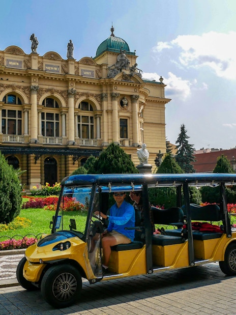 Electric car tour passing by the Juliusz Słowacki Theatre in Krakow.