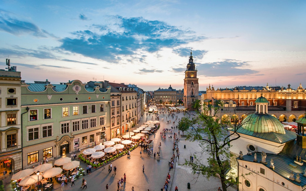 Krakow's Main Square at sunset with St. Mary's Basilica and Cloth Hall.