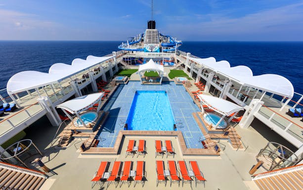 Cruise ship deck with pool and lounge chairs on World Dream Getaway Cruise.