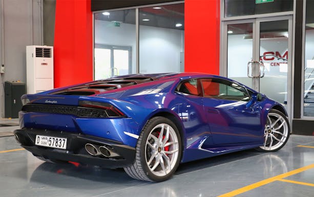 Blue Lamborghini in a showroom for luxury supercar driving experience in Dubai.