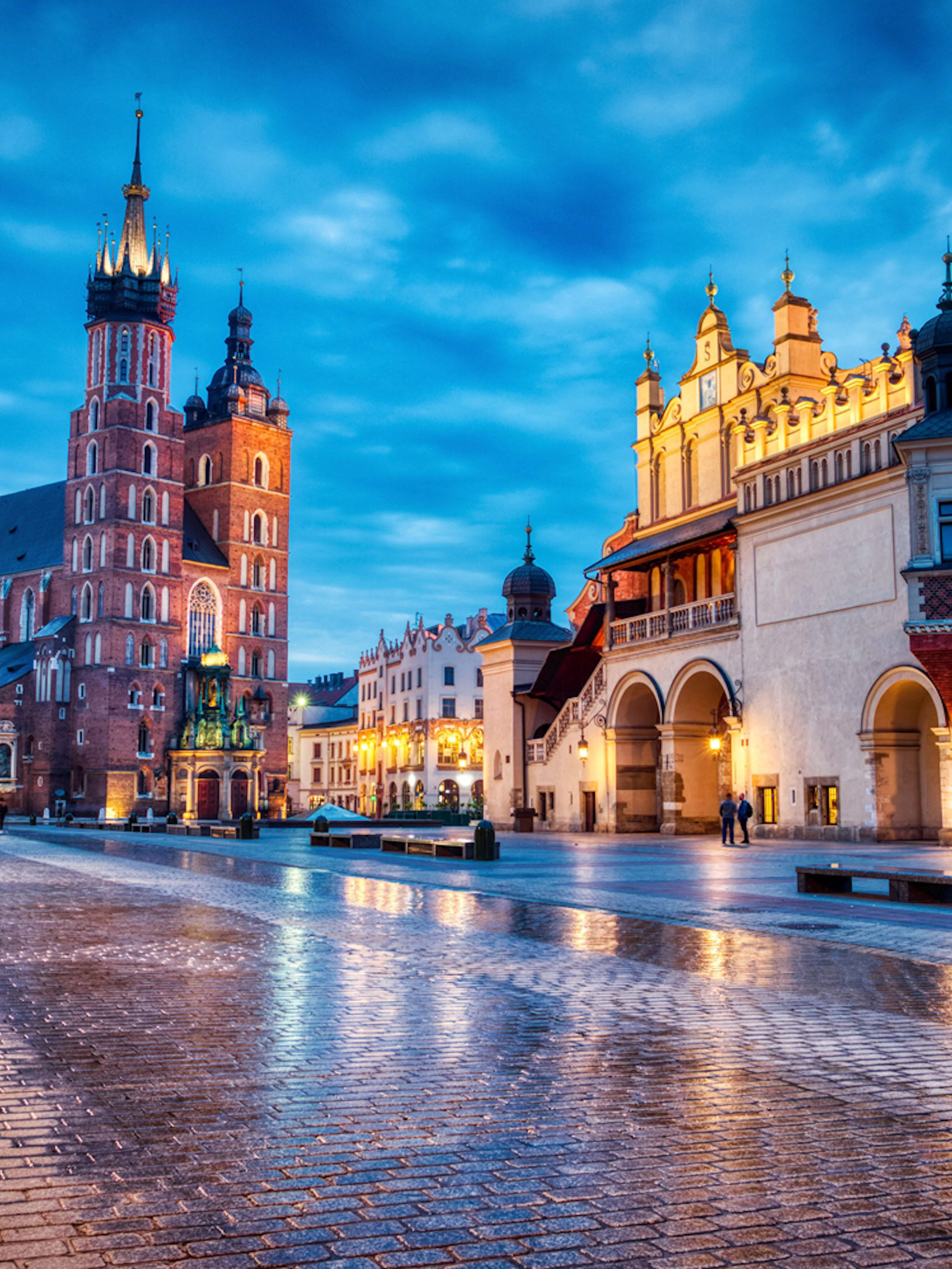 Krakow's Main Square at dusk with St. Mary's Basilica and Cloth Hall.