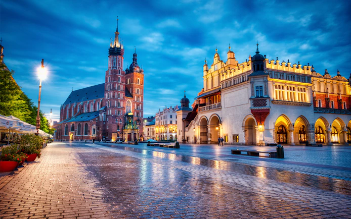Krakow's Main Square at dusk with St. Mary's Basilica and Cloth Hall.