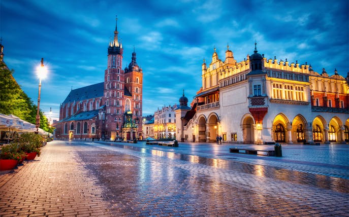 Krakow's Main Square at dusk with St. Mary's Basilica and Cloth Hall.