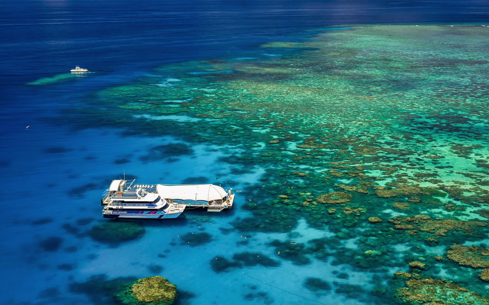 Cruise ship anchored near vibrant coral reefs at Great Barrier Reef, Australia.