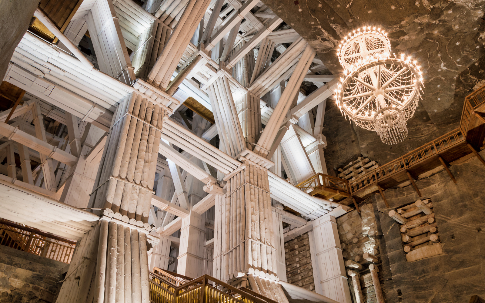 Wieliczka Salt Mine interior with wooden supports and chandelier, Krakow tour.