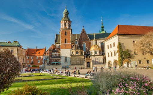 Wawel Cathedral on Wawel Hill, Krakow, with tourists exploring the historic site.