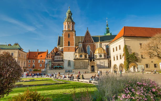 Wawel Cathedral on Wawel Hill, Krakow, with tourists exploring the historic site.