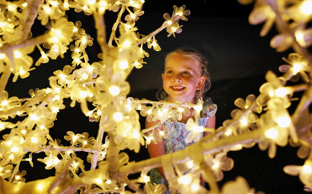 Child admiring illuminated decorations at Hunter Valley Gardens Christmas Lights Spectacular.