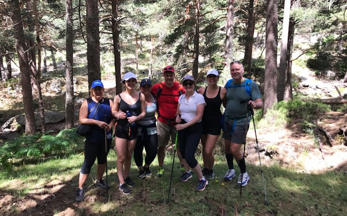 Group hiking in Guadarrama National Park, Madrid, surrounded by pine trees.