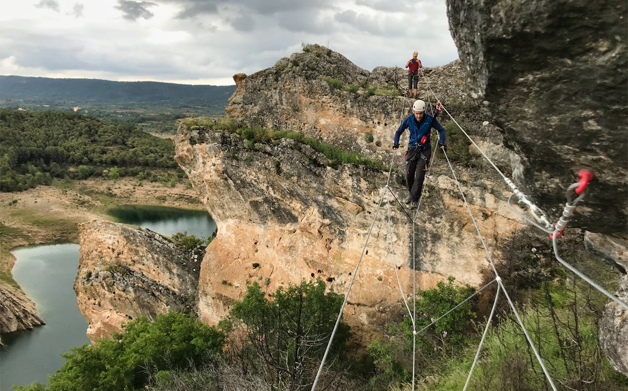 Climbers crossing a rope bridge on Via Ferrata Boca del Infierno in Madrid.