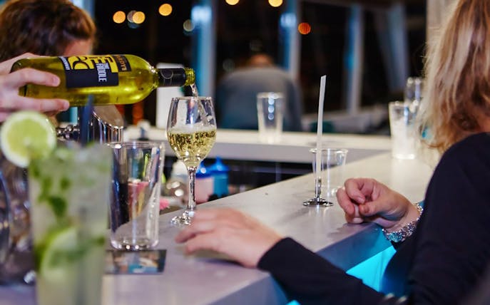 Wine being poured at a bar during Sea World dinner cruise with live entertainment.